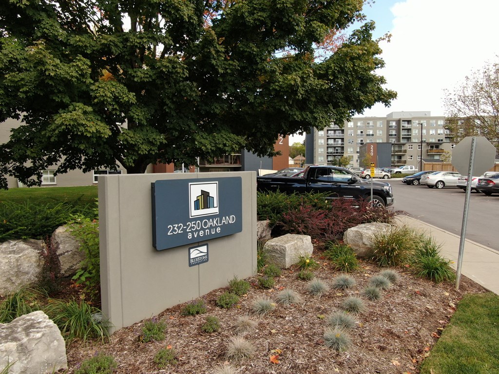 a sign in front of a building with a tree in the background