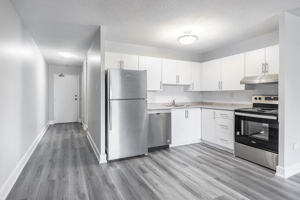a renovated kitchen with stainless steel appliances and white cabinets