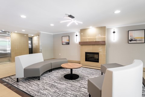 A modern living room with a fireplace and grey couches  at Platts Crossing, London, ON, N6H 4P4