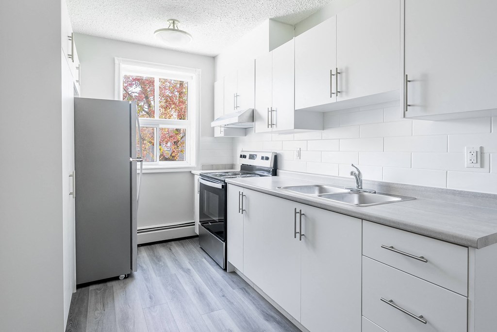 Oakland kitchen with white cabinets and a grey fridge.
