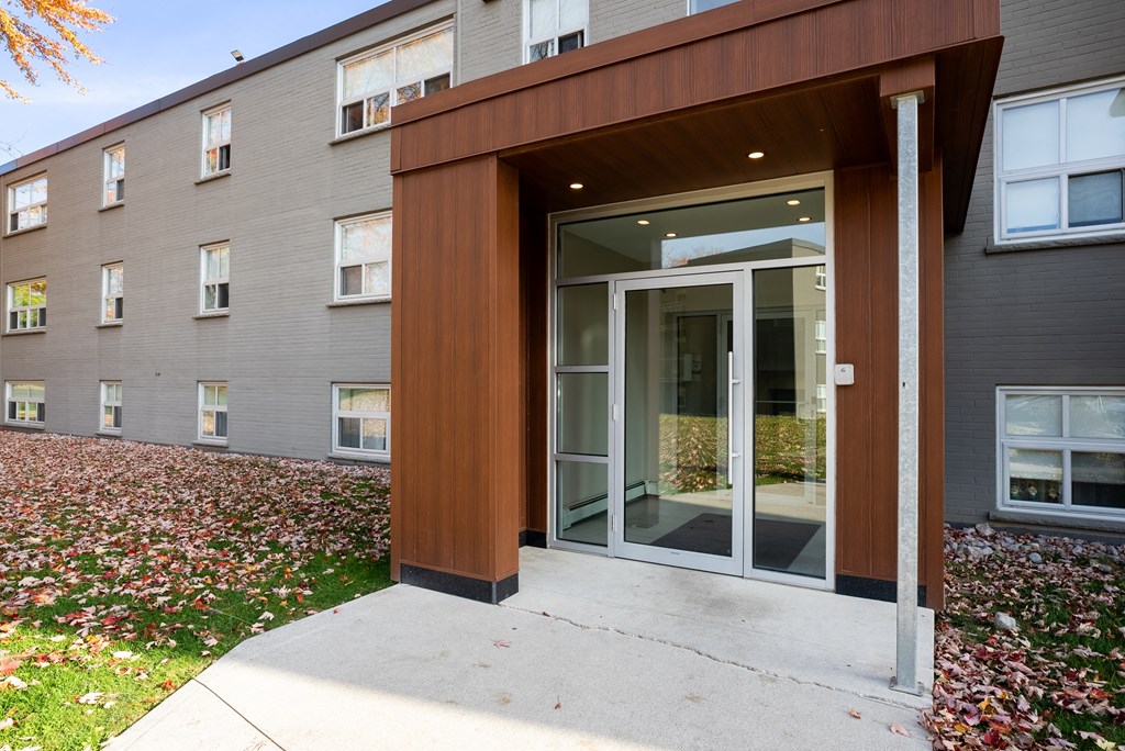 The modern building entrance with a brown wood accents at Oakland Avenue
