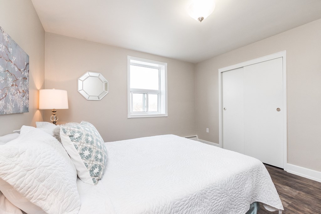 a bedroom with a large white bed and a window