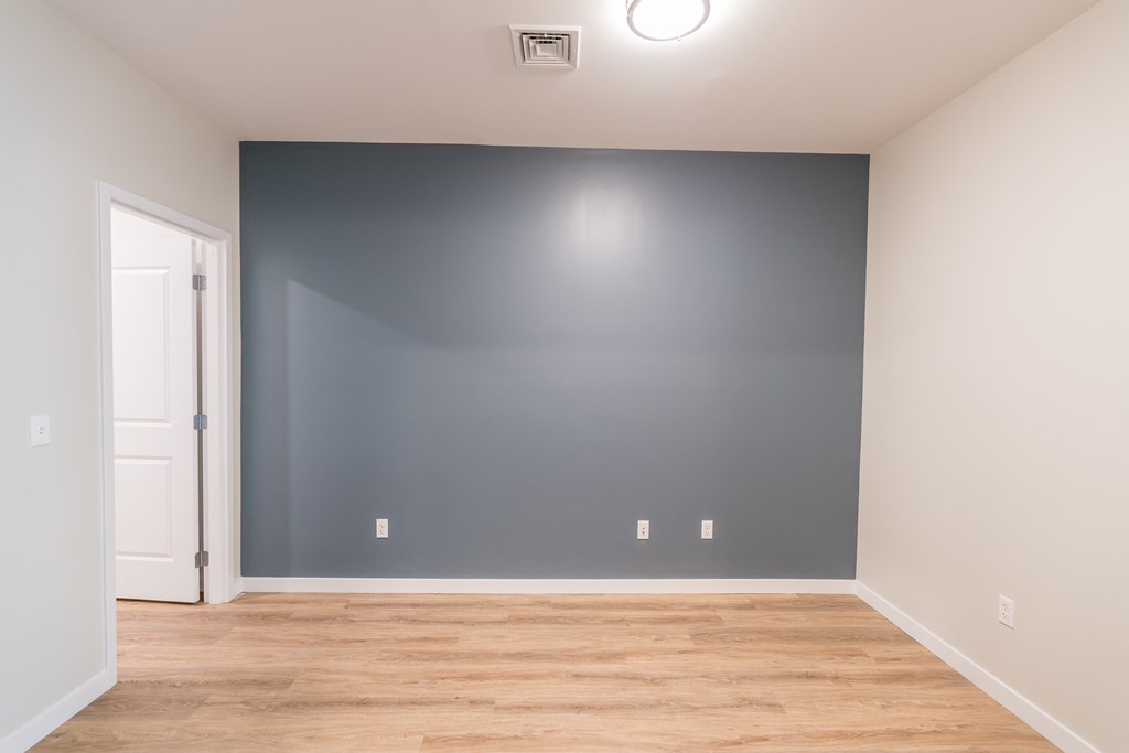 an empty room with a blue accent wall