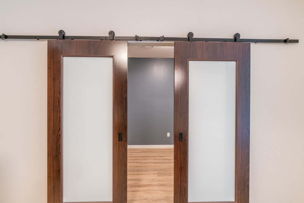 a couple of wooden doors with white frosted glass in a room with hardwood floors