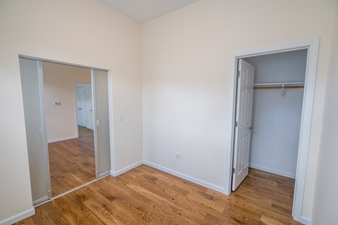 a bedroom with hardwood floors and white walls
