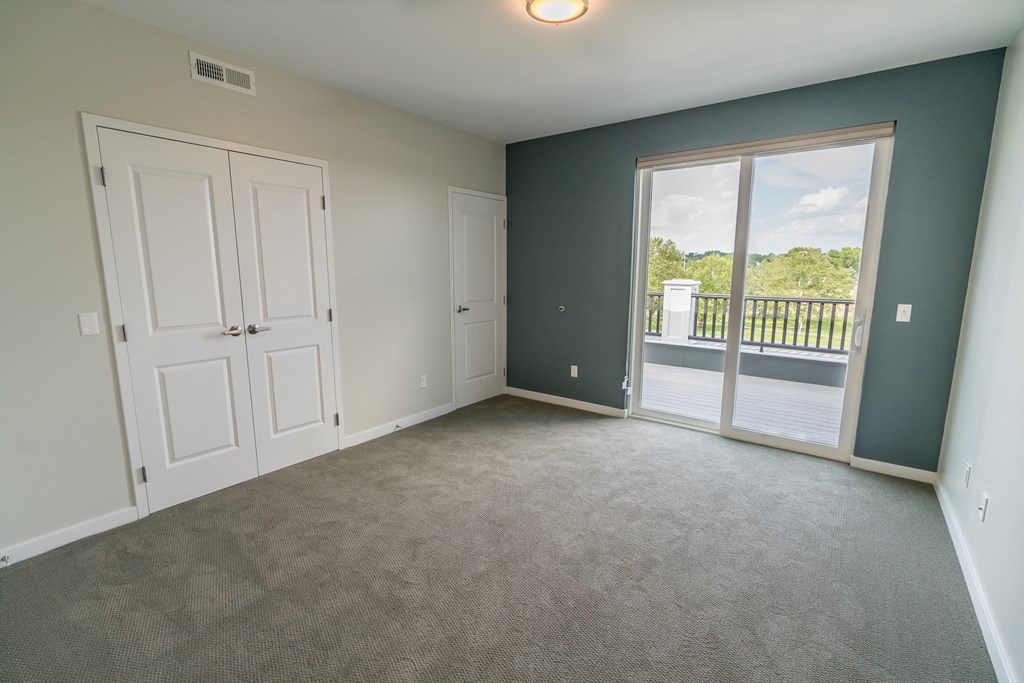 a bedroom with a balcony and a door that leads to a balcony