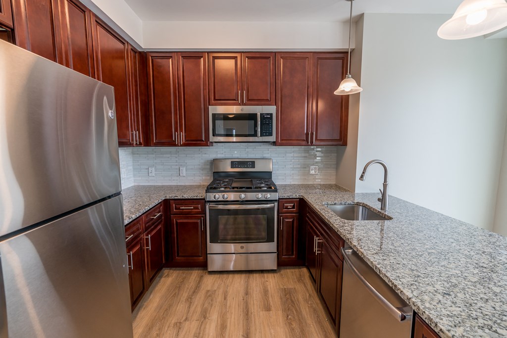 a kitchen with wood cabinets and stainless steel appliances