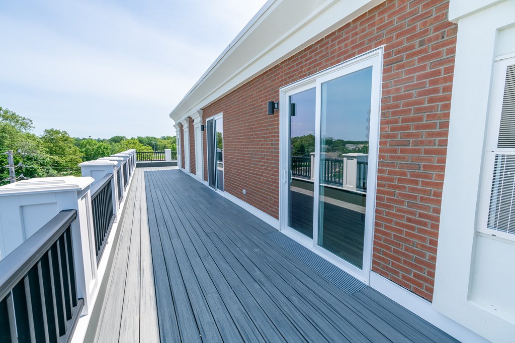 a large balcony with a door that leads into the living room