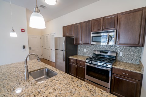 a kitchen with granite countertops and stainless steel appliances
