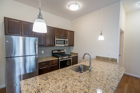 a kitchen with granite counter tops and a stainless steel refrigerator