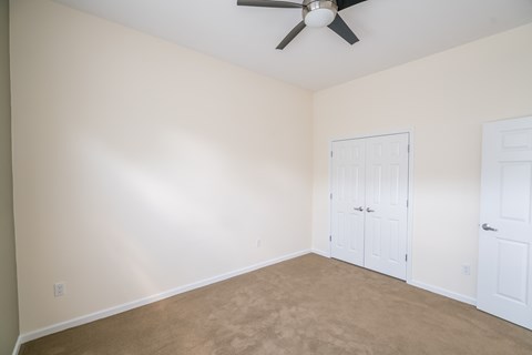 a bedroom with a ceiling fan and a door