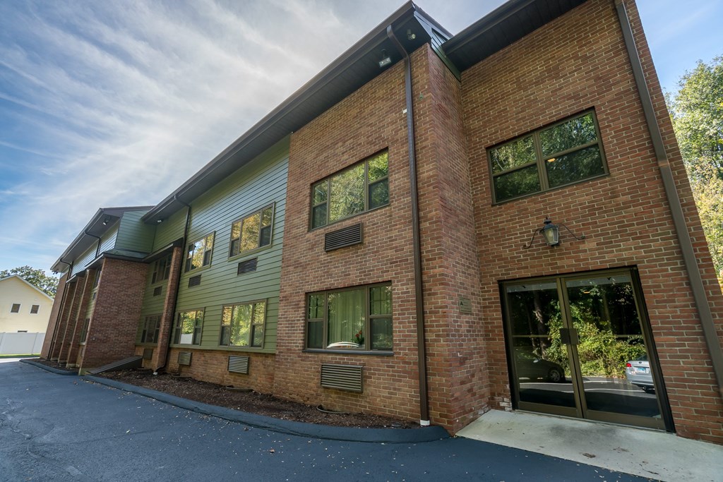 the exterior of a brick building with a driveway