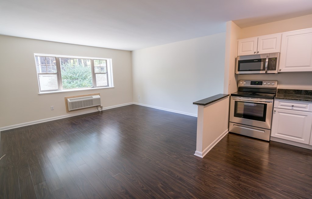an empty kitchen with white cabinets and stainless steel appliances