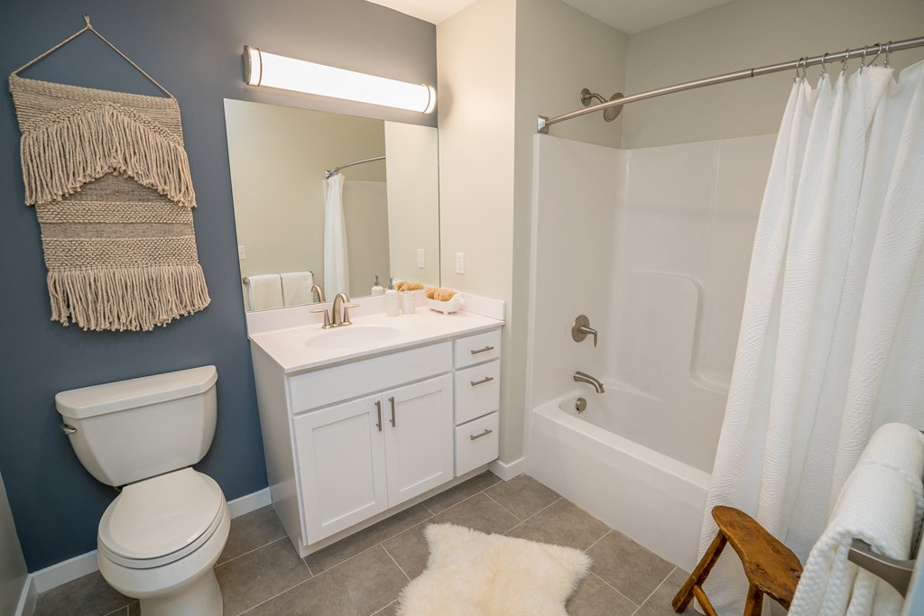 a bathroom with a white sink and toilet next to a white bathtub