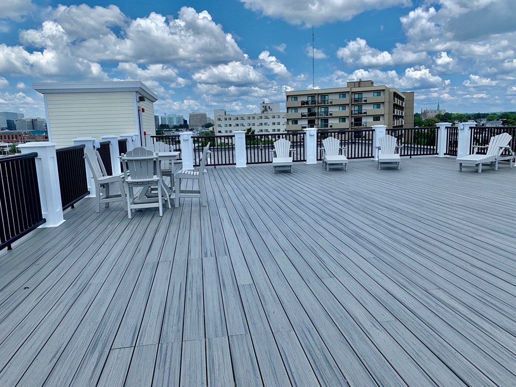 a rooftop deck with chairs and a table