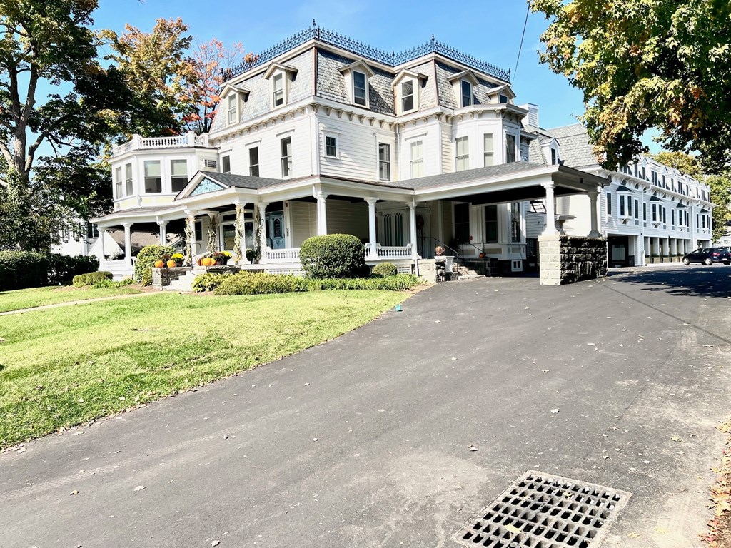 a large white house with a driveway in front of it
