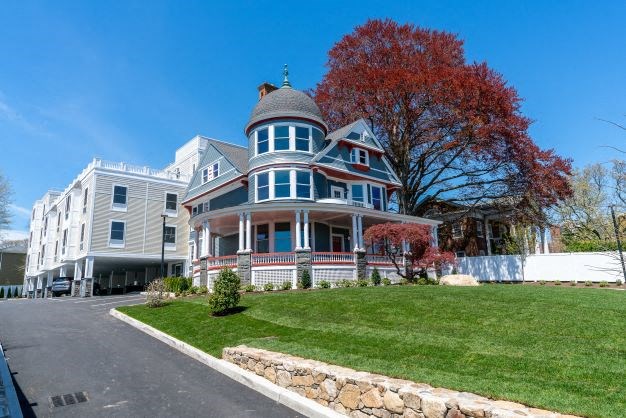 a large house on a hill with a tree in the background