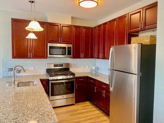 a kitchen with a stove a refrigerator and a sink