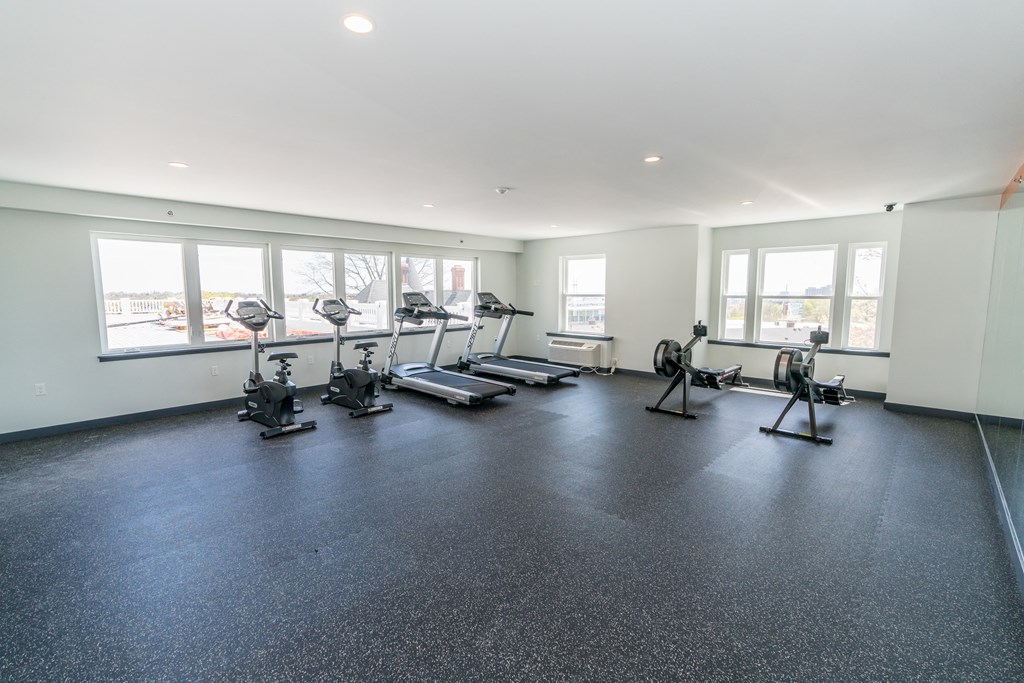 a spacious exercise room with treadmills and elliptical trainers