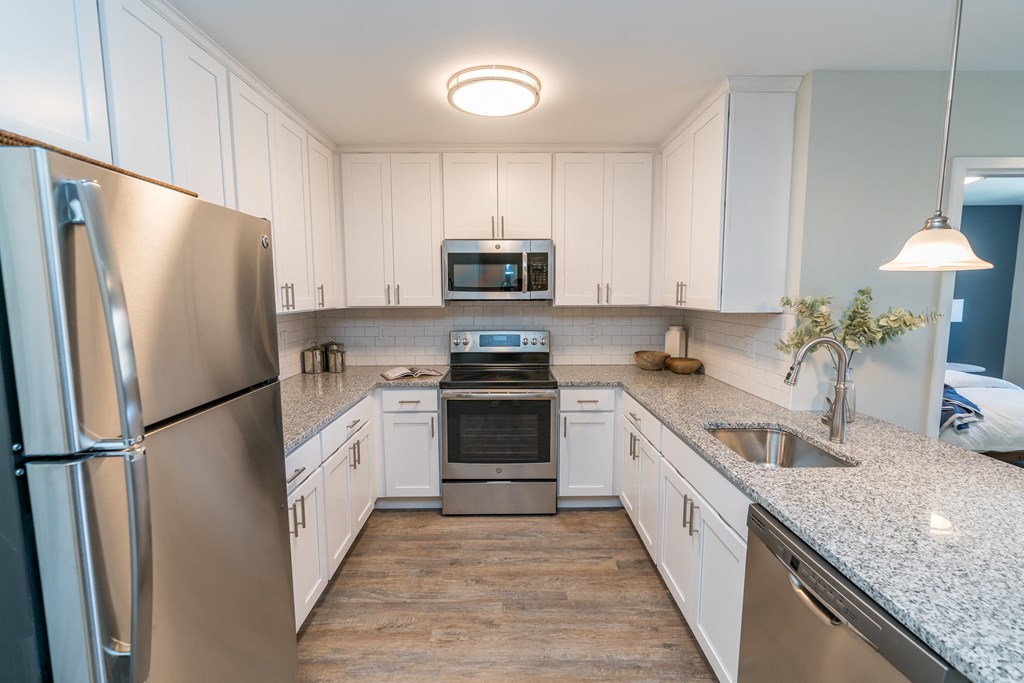 a kitchen with white cabinets and stainless steel appliances
