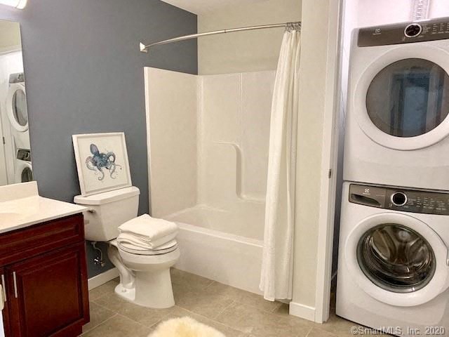 a bathroom with a toilet and a washer in it