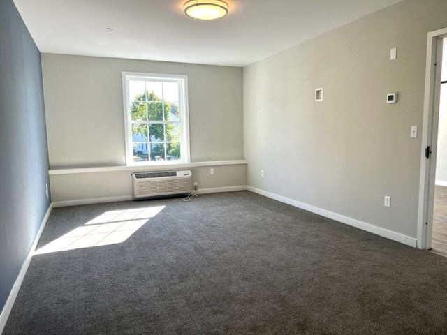 an empty room with a window and a radiator
