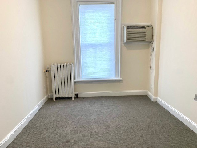 an empty room with a radiator and a window