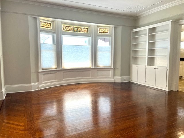 a living room with a wooden floor and a large window
