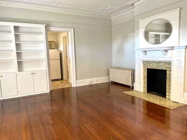 a living room with a fireplace and wooden floors
