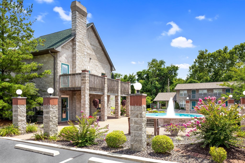 an exterior view of a building with a pool and a fountain