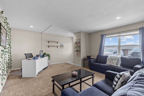 a living room with couches and a coffee table and a window