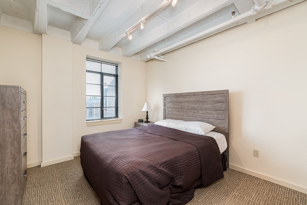 a bedroom with a bed and a window