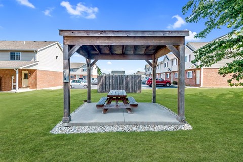 a picnic table sitting under a pavilion in a yard