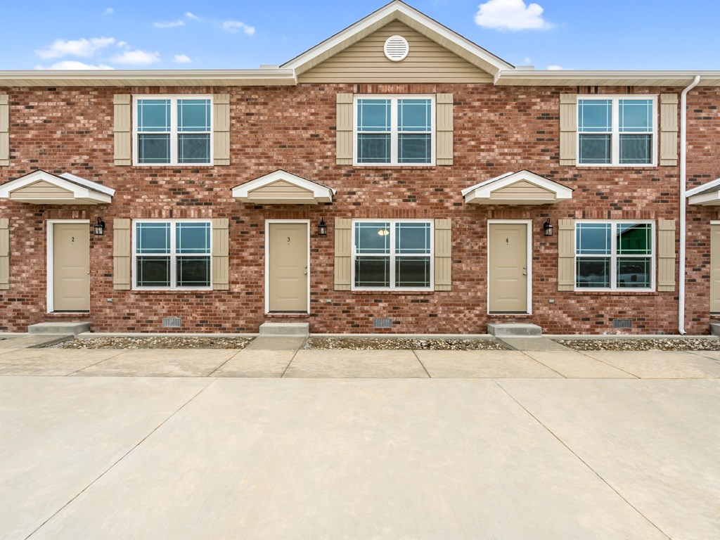 a red brick building with windows and a sidewalk