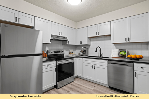 A kitchen with white cabinets and a black fridge.