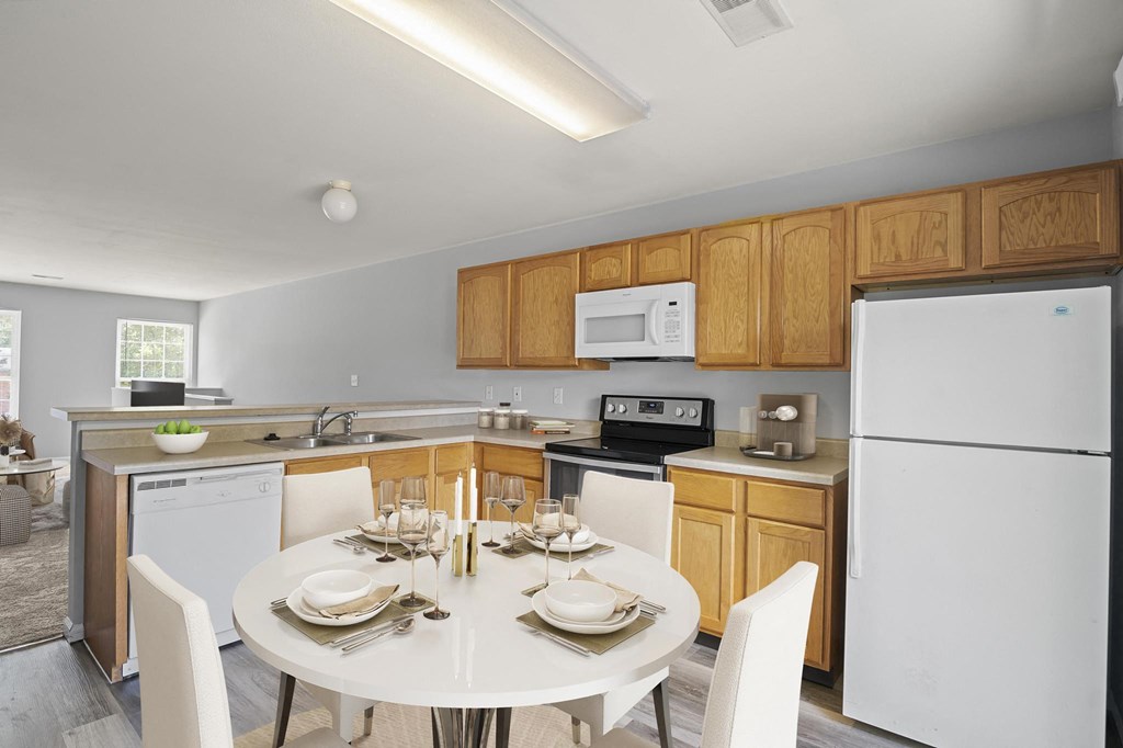 a kitchen with a white table and chairs and a white refrigerator