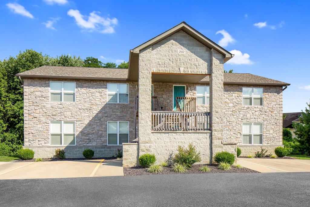 a large stone house with a balcony on a sunny day