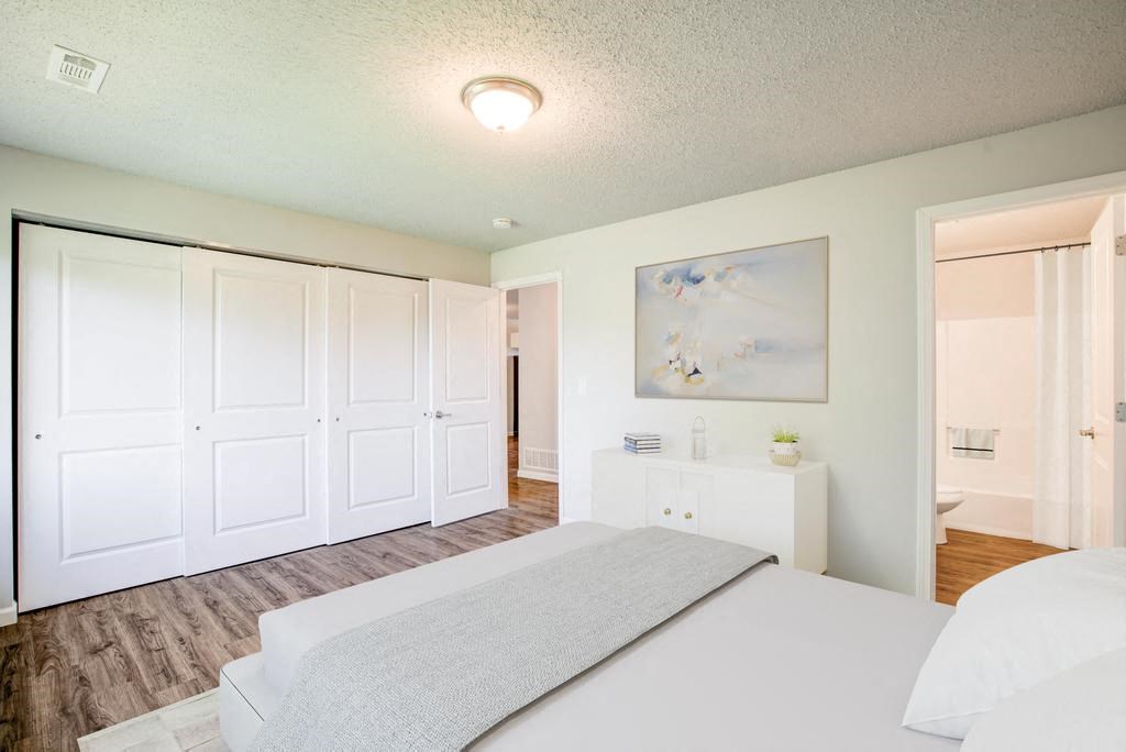 a bedroom with a bed and a dresser in front of it