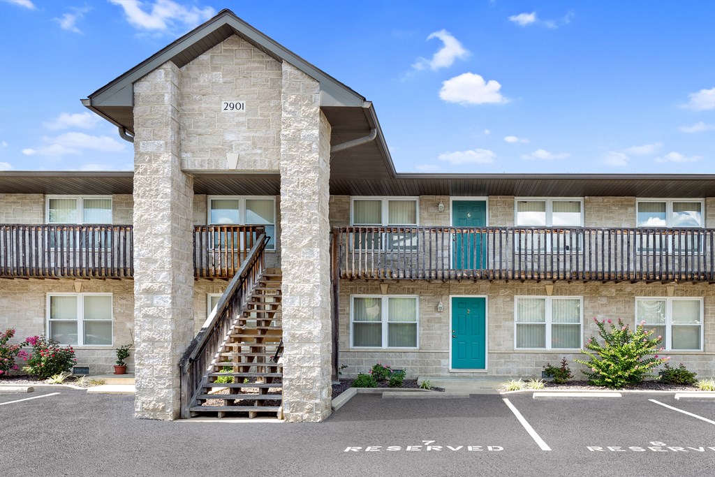 the front of a building with stairs and a blue door