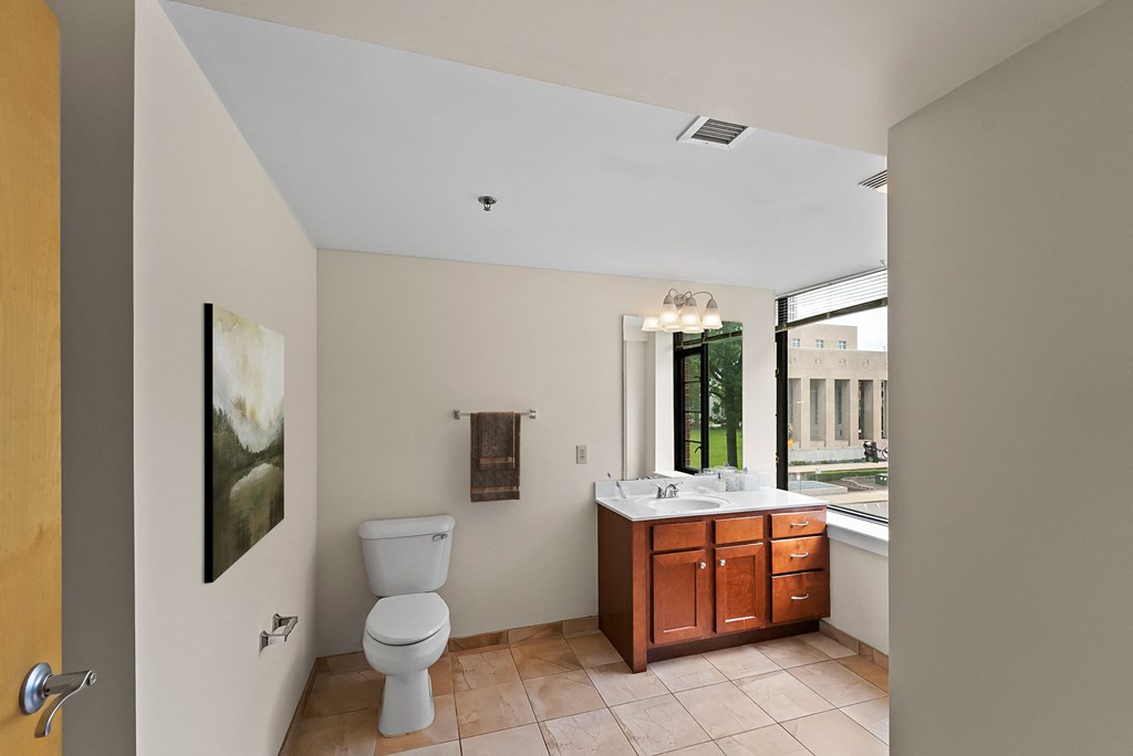 a bathroom with a toilet and a sink and a window