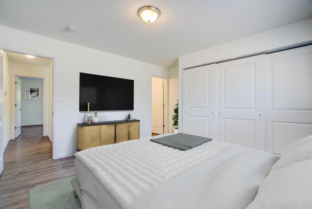 a bedroom with a large bed and a flat screen tv