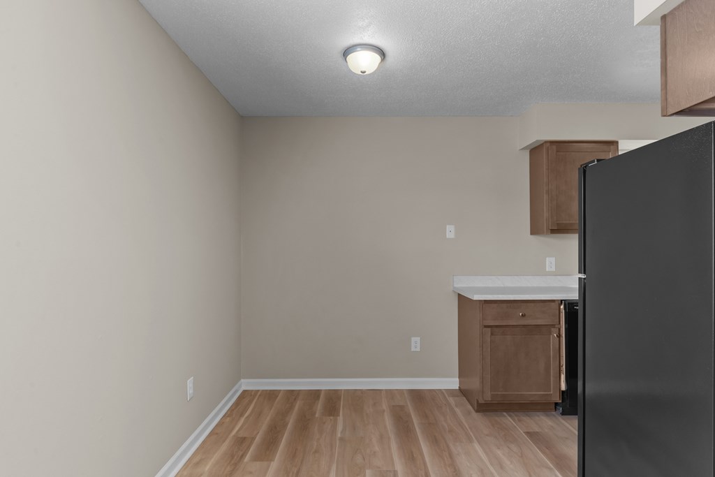 an empty kitchen with a refrigerator and a counter top