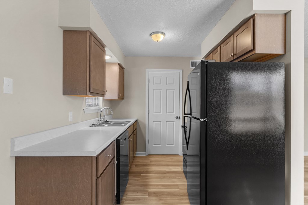 an empty kitchen with a refrigerator and a sink
