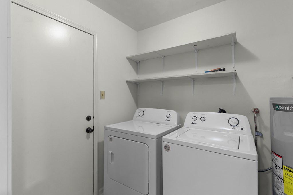 a white laundry room with two washes and a dryer