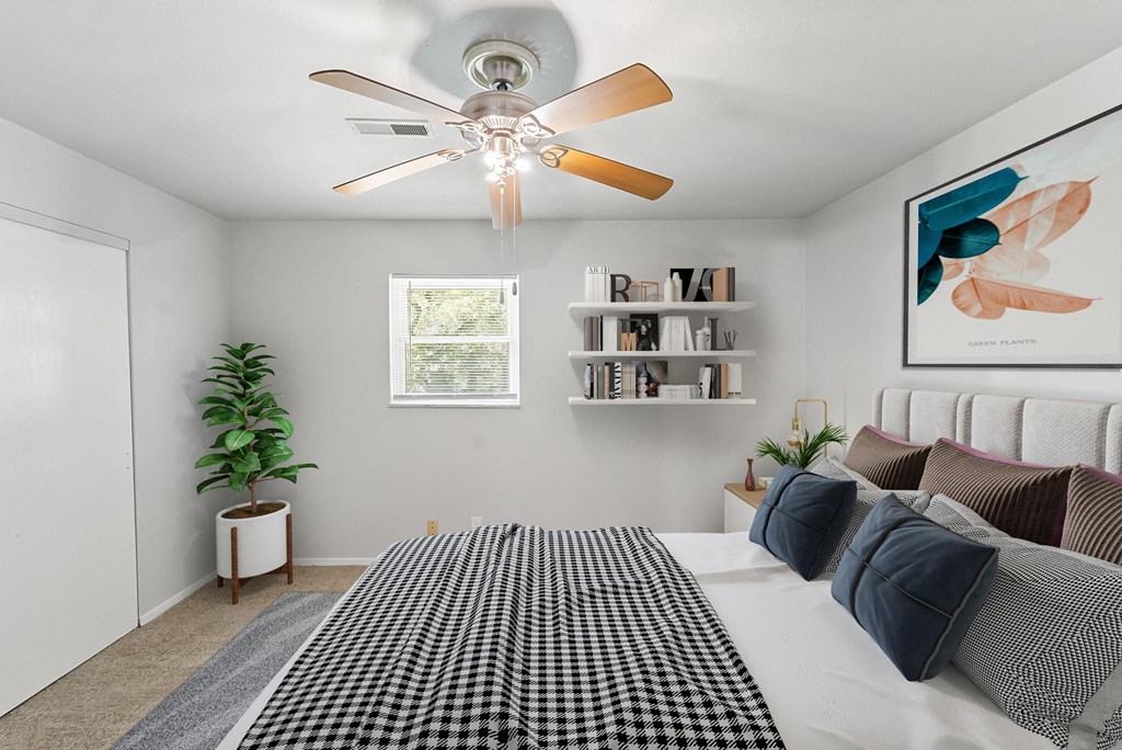 a bedroom with a large bed and a ceiling fan