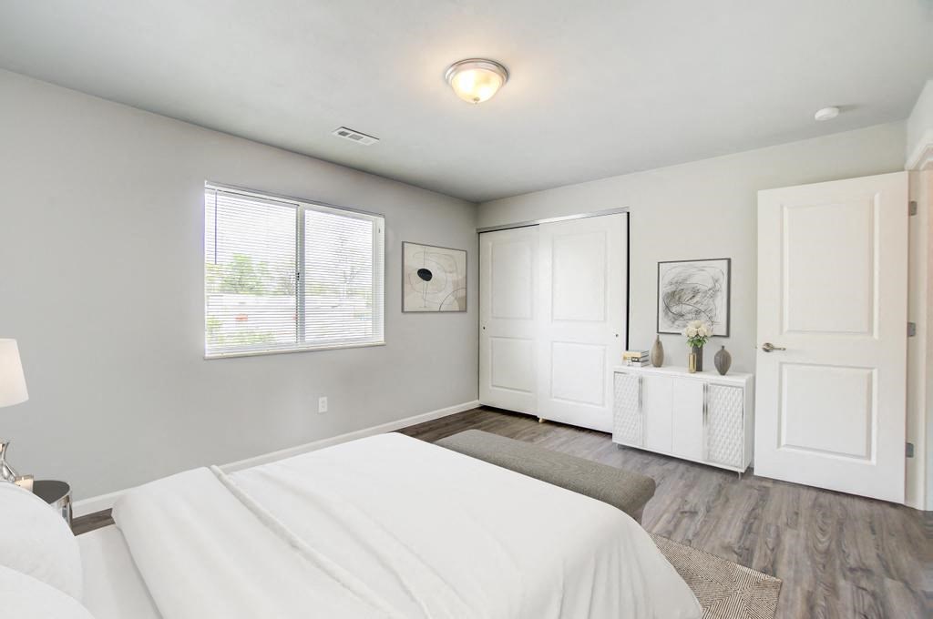 a bedroom with a white bed and a white dresser
