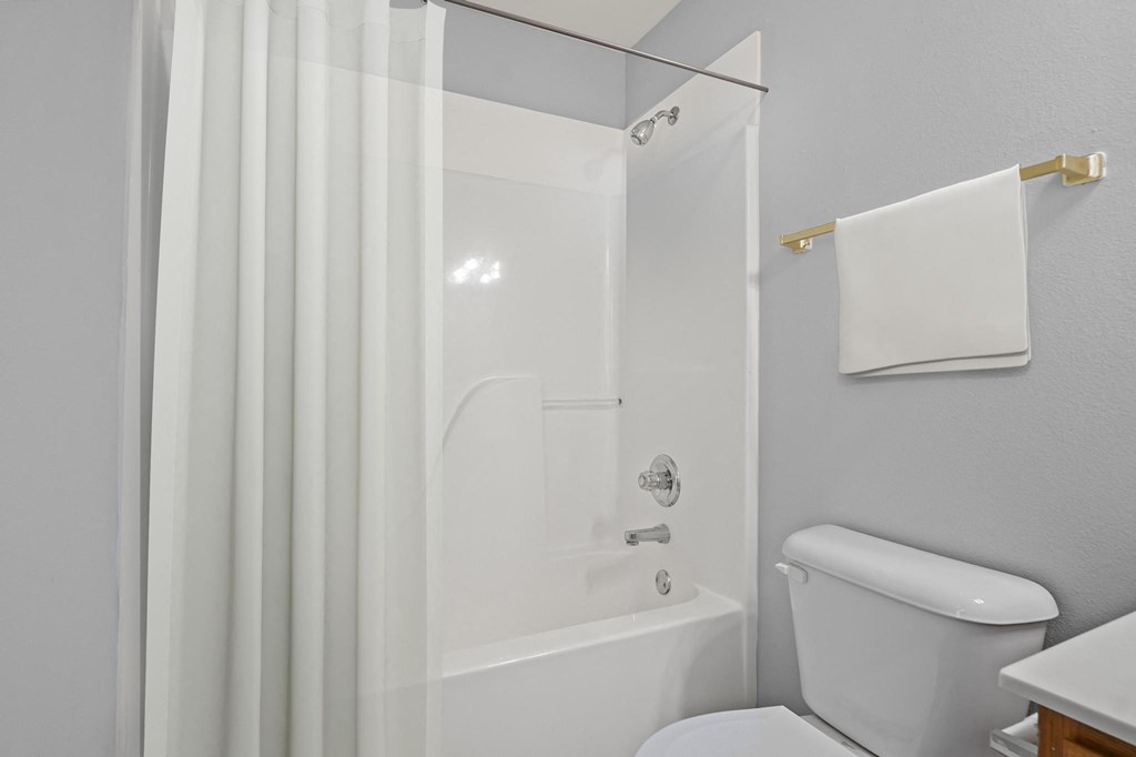 a bathroom with a white tub and a white shower curtain