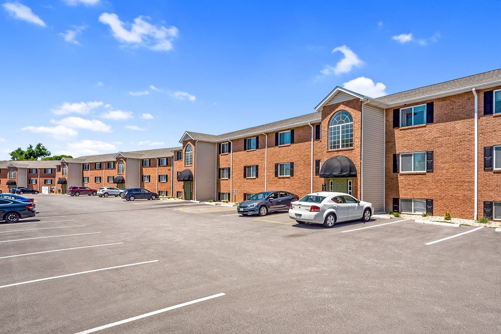 an empty parking lot in front of a brick building