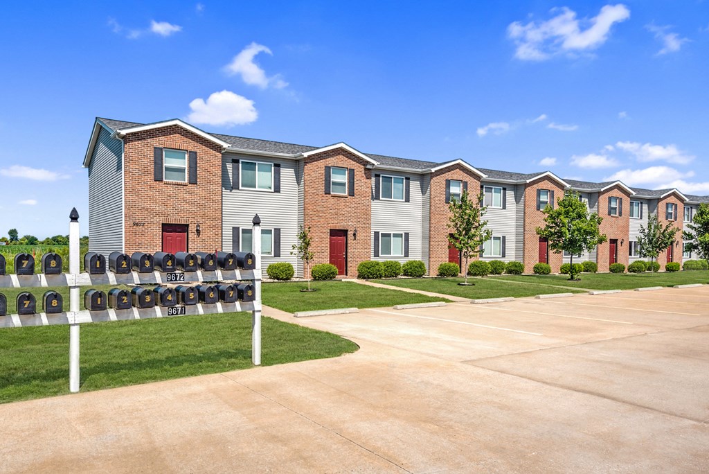 a row of brick apartment buildings with red doors