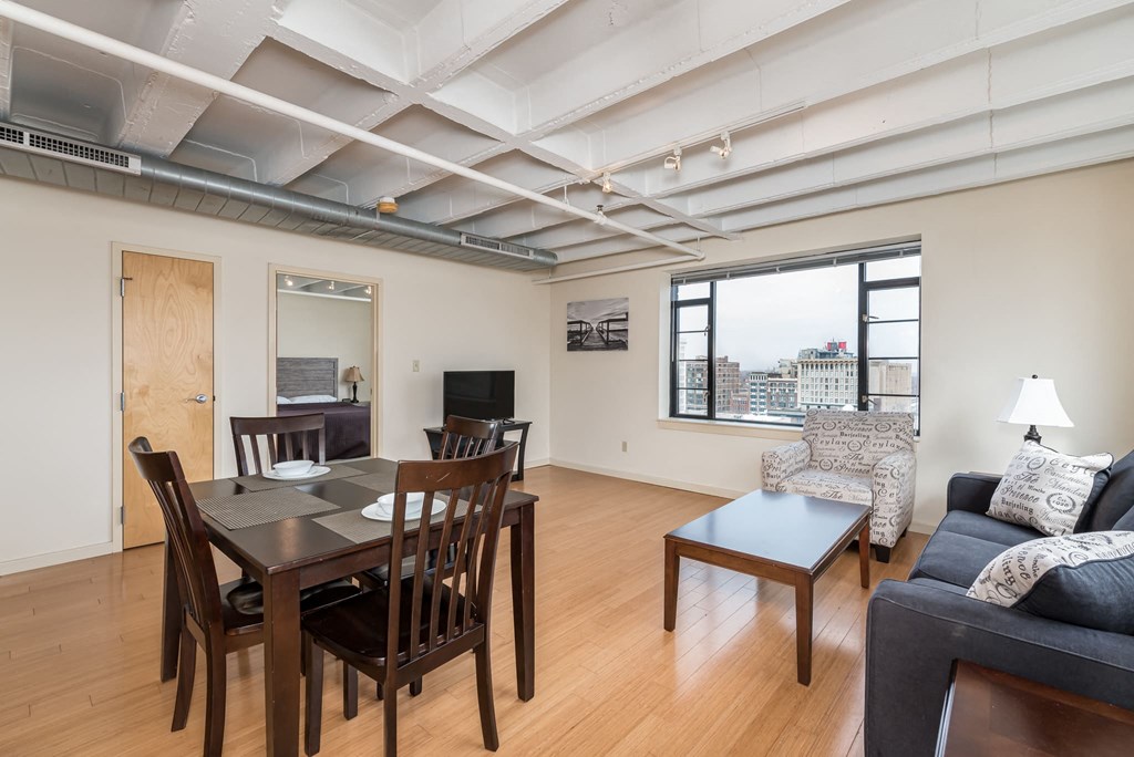 a living room and dining room with a table and chairs